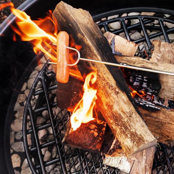 Hot dog roasted on Walden Extendable Roasting Stick over a fire pit grate