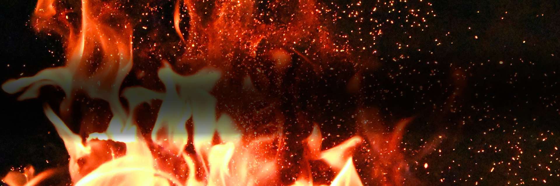 Bonfire blowing in the night with sparkling embers flying in all directions