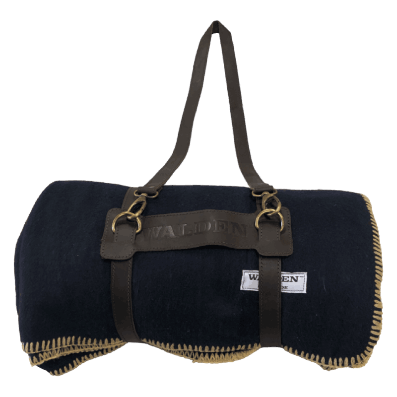 Warm heavy-duty Walden blanket in midnight blue suspended by a brown leather strap.
