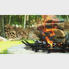 tall stacked firewood burning over wagone wheel style fire grate for better airflow and cleaner burn